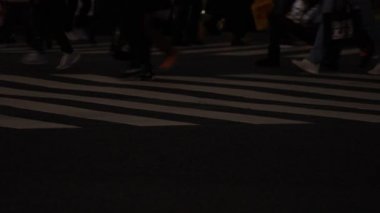 Shibuya geçidinde yürüyen insanların vücut parçaları gece