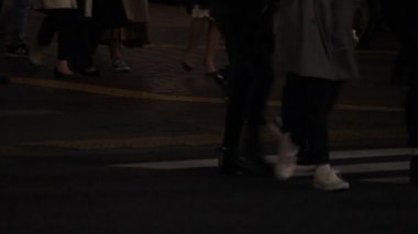 Shibuya geçidinde yürüyen insanların vücut parçaları gece