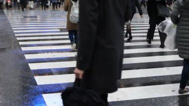 Tokyo yağmurlu bir günde Shibuya geçişinde yürüyüş insanlar