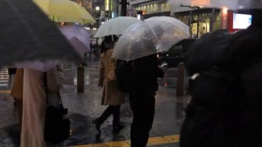 Tokyo yağmurlu bir günde Shibuya geçişinde yürüyüş insanlar