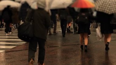 Tokyo yağmurlu bir günde Shibuya geçişinde yürüyüş insanlar