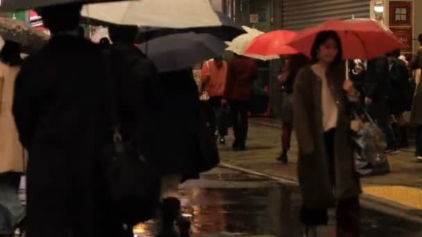 Spaziergänger am Shibuya-Übergang bei Tokyo-Regen — Stockvideo