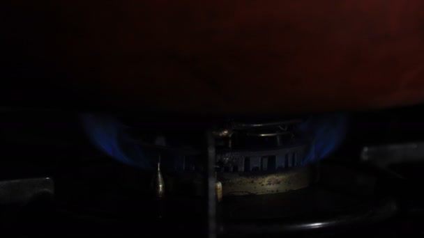 Allumage de la chaleur sous la casserole rouge dans la cuisine — Video