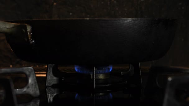 Encendido del calor debajo de la cacerola negra en la cocina — Vídeo de stock