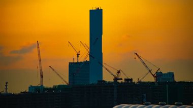 Alacakaranlıkta Tokyo'da yapım aşamasında hareketli vinçler bir zaman atlama
