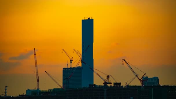 Un lapso de tiempo de grúas móviles en construcción en Tokio al atardecer — Vídeos de Stock