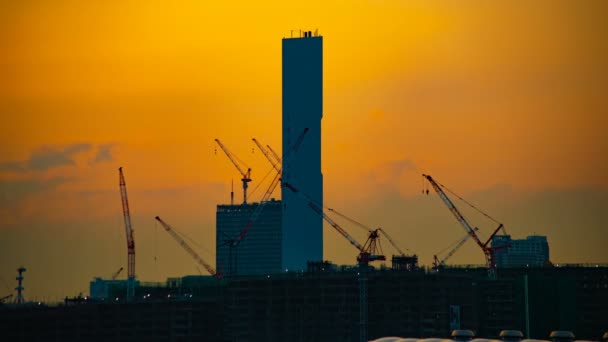 Zeitraffer fahrender Kräne im Bau in Tokio in der Abenddämmerung — Stockvideo