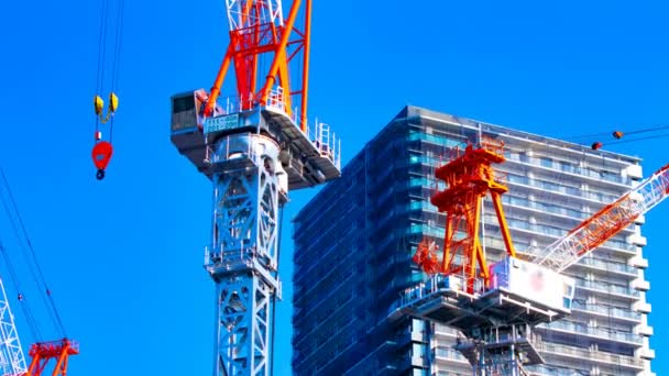 Un lapso de tiempo de grúas en movimiento en la construcción en Tokio zoom — Vídeo de stock