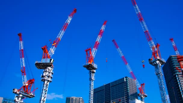 Um lapso de tempo de guindastes em movimento na construção em Tóquio tiro largo panning — Vídeo de Stock