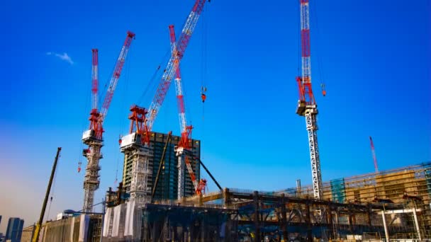 Un lapso de tiempo de grúas en movimiento en la construcción en Tokio inclinación de tiro ancho — Vídeo de stock