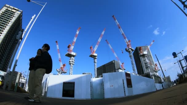 En tidsfördröjning av rörliga kranar på under konstruktion i Tokyo wide shot — Stockvideo