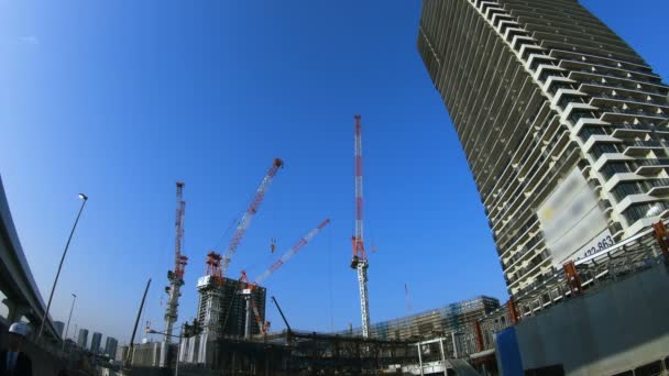 Un lapso de tiempo de grúas en movimiento en la construcción en Tokio tiro ancho — Vídeo de stock