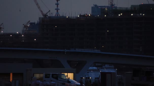 Kranen in de aanbouw in Tokio Wide shot 's nachts — Stockvideo