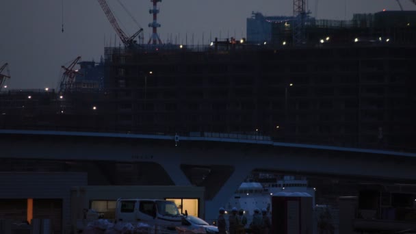 Kranen in de aanbouw in Tokio Wide shot 's nachts — Stockvideo