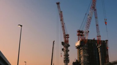 Tokyo'da yapım aşamasında vinçler alacakaranlıkta geniş atış