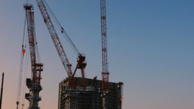 Tokyo'da yapım aşamasında vinçler alacakaranlıkta geniş atış