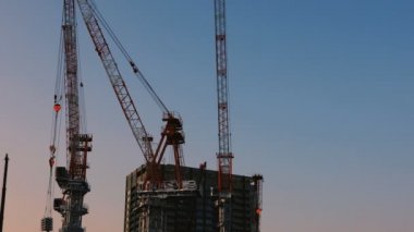 Tokyo'da yapım aşamasında vinçler alacakaranlıkta geniş atış