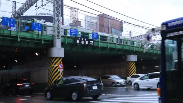 Bewegende auto's op de kruising in Shinjuku Tokyo regenachtige dag — Stockvideo