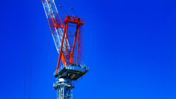 Un lapso de tiempo de grúas en movimiento detrás del cielo azul en la construcción en Tokio — Vídeo de stock