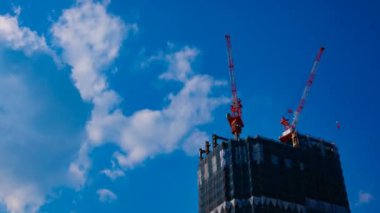 Tokyo'da mavi gökyüzünün arkasında yapım aşamasında vinçler bir timelapse