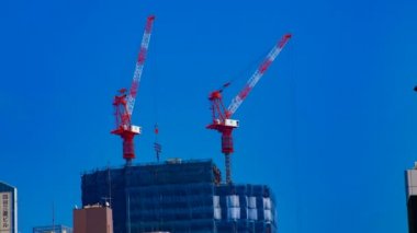 Tokyo'da mavi gökyüzünün arkasında yapım aşamasında vinçler bir timelapse
