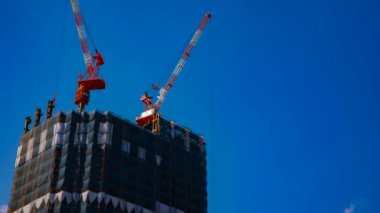 Tokyo'da mavi gökyüzünün arkasında yapım aşamasında vinçler bir timelapse