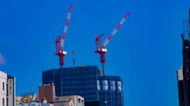 Tokyo'da mavi gökyüzünün arkasında yapım aşamasında vinçler bir timelapse