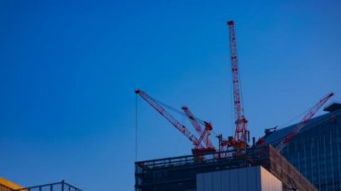 Tokyo'da mavi gökyüzünün arkasında yapım aşamasında vinçler bir timelapse