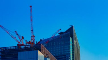 Tokyo'da mavi gökyüzünün arkasında yapım aşamasında vinçler bir timelapse