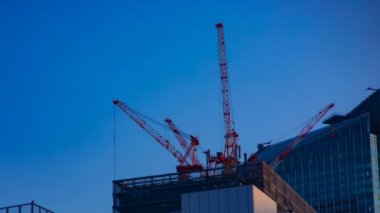 Tokyo'da mavi gökyüzünün arkasında yapım aşamasında vinçler bir timelapse