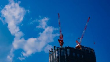 Tokyo'da mavi gökyüzünün arkasında yapım aşamasında vinçler bir timelapse