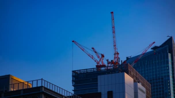 A timelapse of cranes at the under construction behind the blue sky in Tokyo — Stock Video