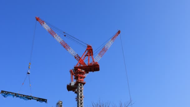 Mozgó daruk az építés alatt mögött a kék eget Tokióban — Stock videók