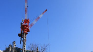 Tokyo'da mavi gökyüzünün arkasında yapım aşamasında vinçler hareketli