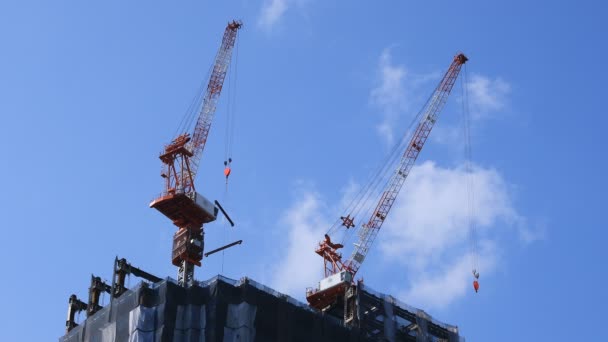 도쿄의 푸른 하늘 뒤에서 공사 중인 크레인을 옮기다 — 비디오
