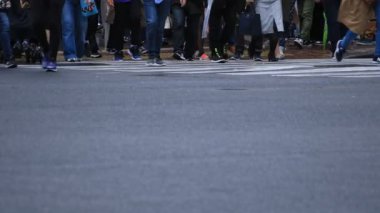 Shibuya Tokyo 'daki geçitte yürüyen insanların bacakları yağmurlu bir günde