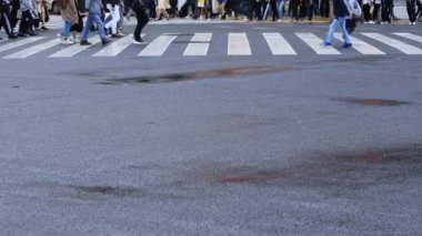 Shibuya Tokyo 'daki geçitte yürüyen insanların bacakları yağmurlu bir günde