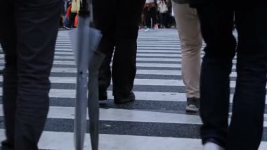 Shibuya Tokyo 'daki geçitte yürüyen insanların bacakları yağmurlu bir günde