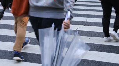 Shibuya Tokyo 'daki geçitte yürüyen insanların bacakları yağmurlu bir günde