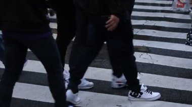 Shibuya Tokyo 'daki geçitte yürüyen insanların bacakları yağmurlu bir günde