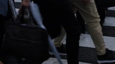 Shibuya Tokyo 'daki geçitte yürüyen insanların bacakları yağmurlu bir günde