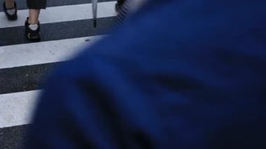 Shibuya Tokyo 'daki geçitte yürüyen insanların bacakları yağmurlu bir günde