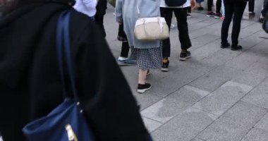 Asakusa'da taş döşeli yolda yürüyen insanların vücut parçaları