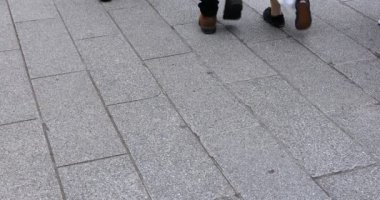 Asakusa'da taş döşeli yolda yürüyen insanların vücut parçaları
