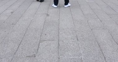Asakusa'da taş döşeli yolda yürüyen insanların vücut parçaları