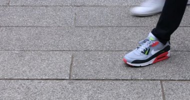 Asakusa'da taş döşeli yolda yürüyen insanların vücut parçaları