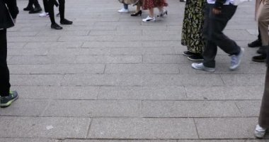 Asakusa'da taş döşeli yolda yürüyen insanların vücut parçaları