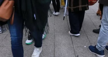 Asakusa'da taş döşeli yolda yürüyen insanların vücut parçaları