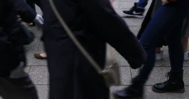 Asakusa'da taş döşeli yolda yürüyen insanların vücut parçaları