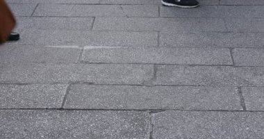 Asakusa'da taş döşeli yolda yürüyen insanların vücut parçaları